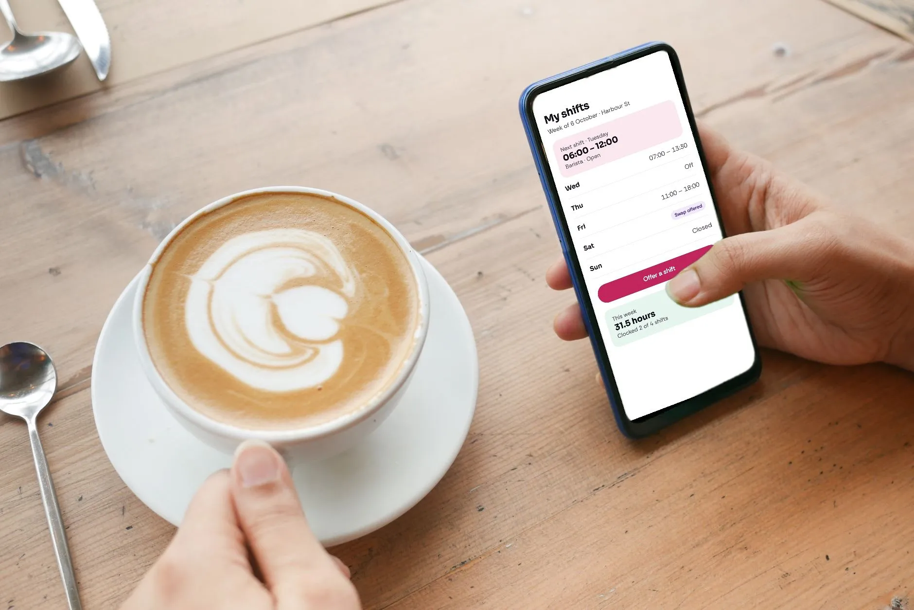 A hand holding a phone showing the Midshift staff app with this week's shifts, beside a cappuccino
